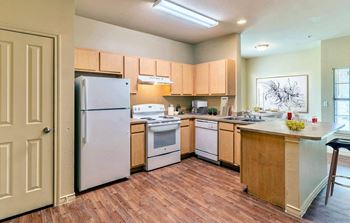 Kitchen with wood cabinets and white appliances3 at Highland Hills, Dallas, TX, 75241
